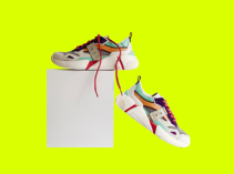 Tênis esportivos brancos com cadarços vermelhos sobre uma caixa branca